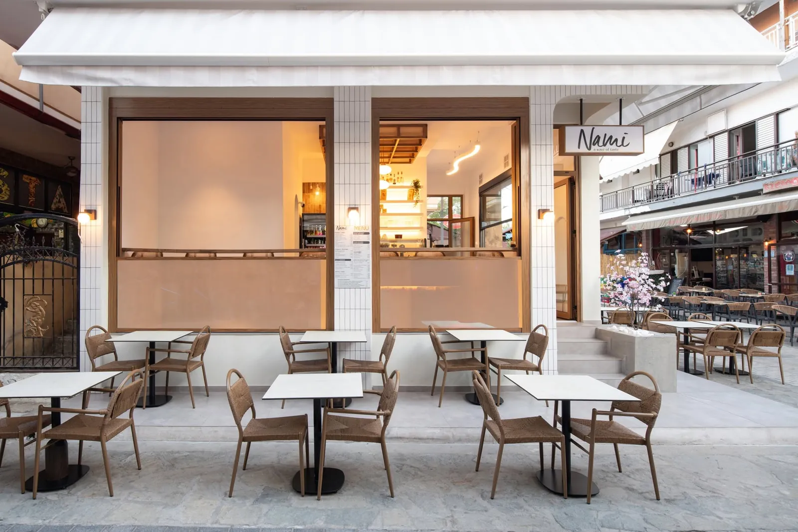 The outdoor seating of Nami with wooden chairs and tables
